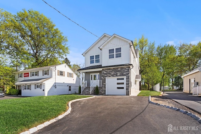 695 Inman Ave, Colonia, NJ 07067 - view of front of house with asphalt driveway, stone siding, board and batten siding, an attached garage, and a front lawn