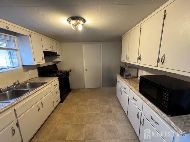 kitchen with light countertops, white cabinets, a sink, under cabinet range hood, and black appliances