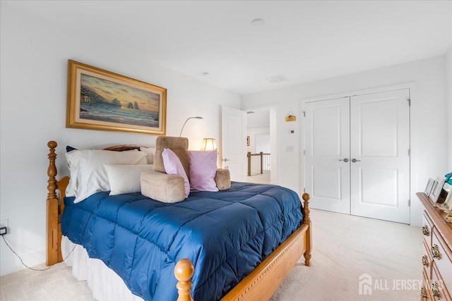 bedroom with light colored carpet and a closet