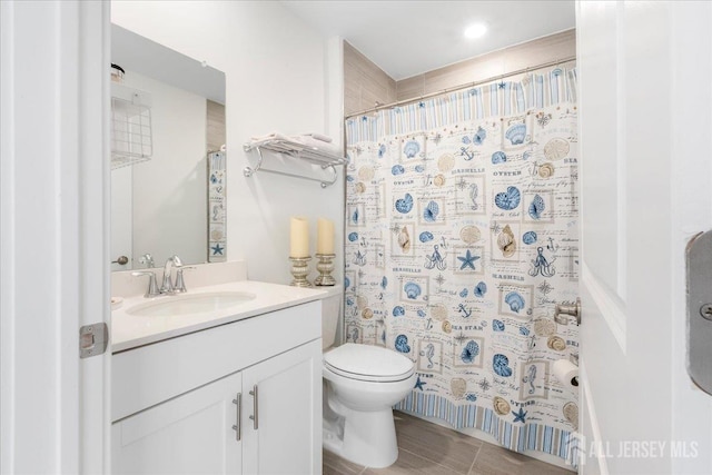 bathroom with vanity, curtained shower, and toilet