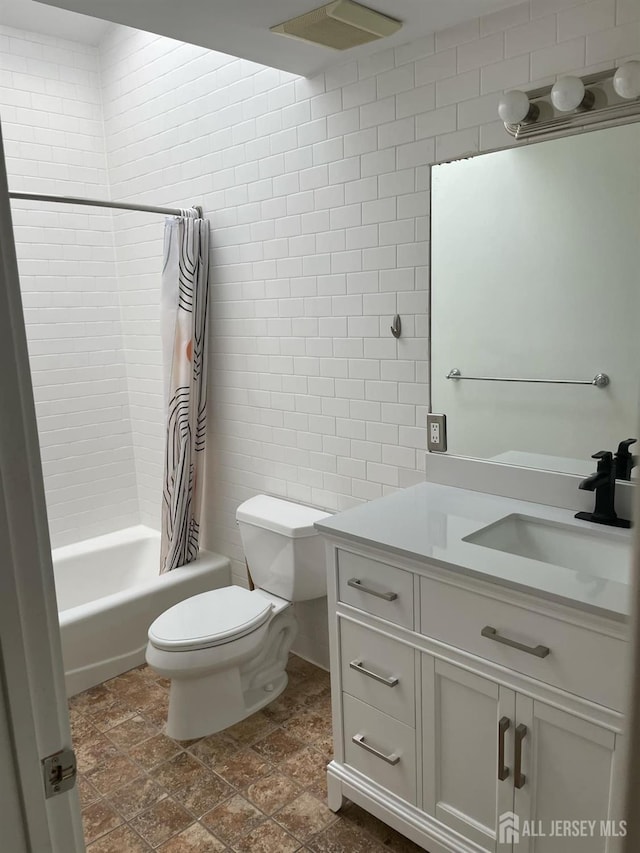 full bathroom with vanity, toilet, tile walls, and shower / tub combo with curtain