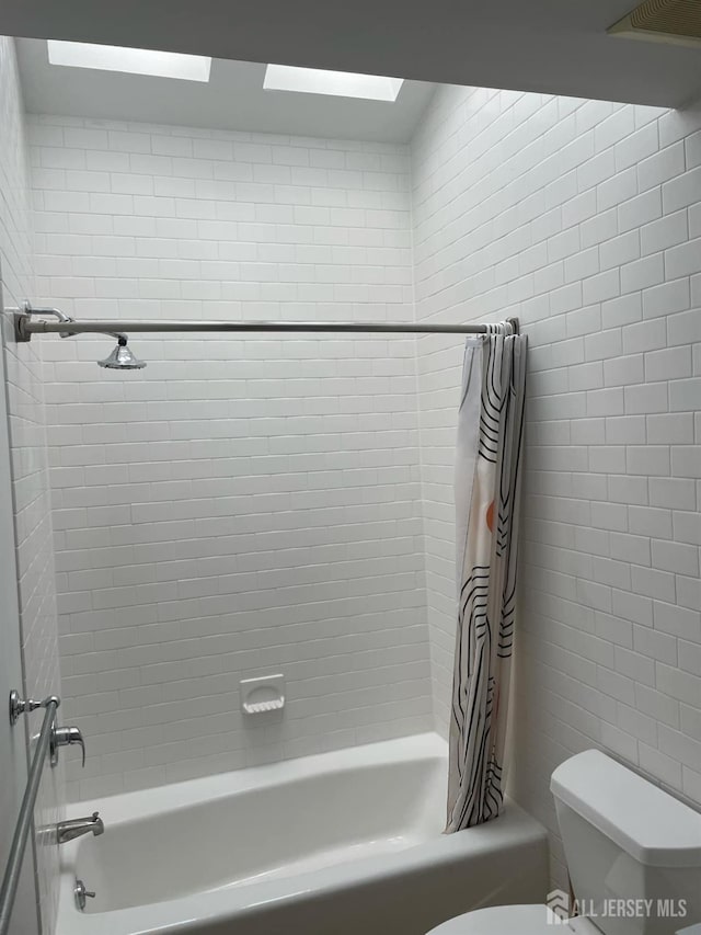 bathroom featuring toilet and shower / bath combo with shower curtain