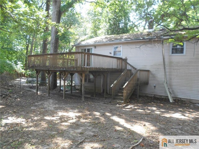 rear view of house featuring a wooden deck