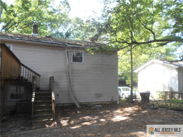 view of side of home with central AC unit