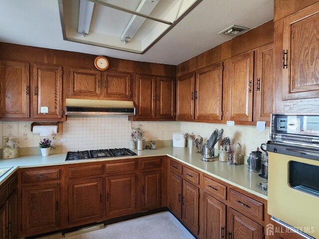 309-C Sharon Way, Monroe, NJ 08831 - kitchen with wall oven, under cabinet range hood, gas cooktop, light countertops, and brown cabinets