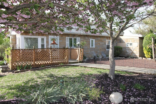 1515 Thomas Ave, North Brunswick, NJ 08902 - back of property with a wooden deck, stone siding, and a yard