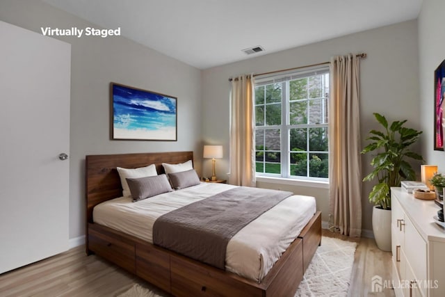 bedroom with light wood finished floors and baseboards