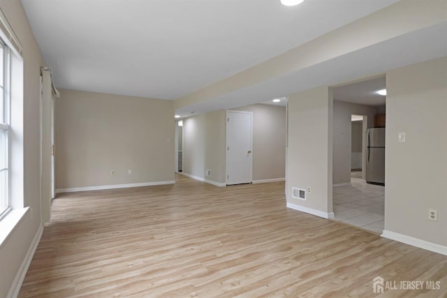 unfurnished living room with light wood finished floors and baseboards
