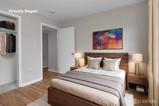 bedroom featuring wood finished floors, a closet, and baseboards