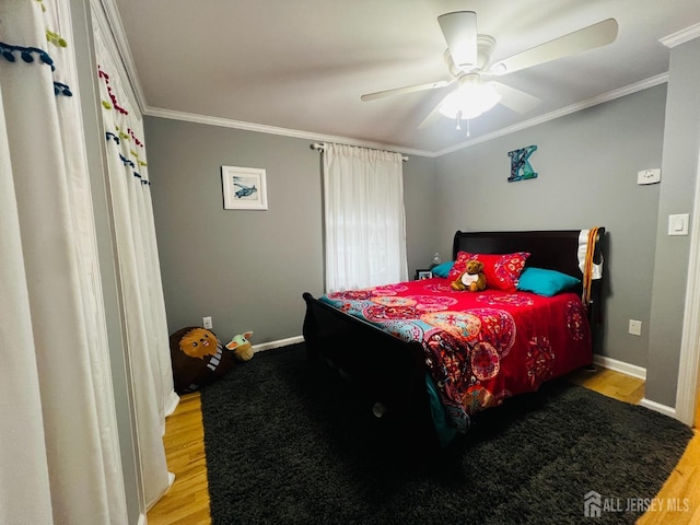 bedroom with ornamental molding, baseboards, a ceiling fan, and wood finished floors