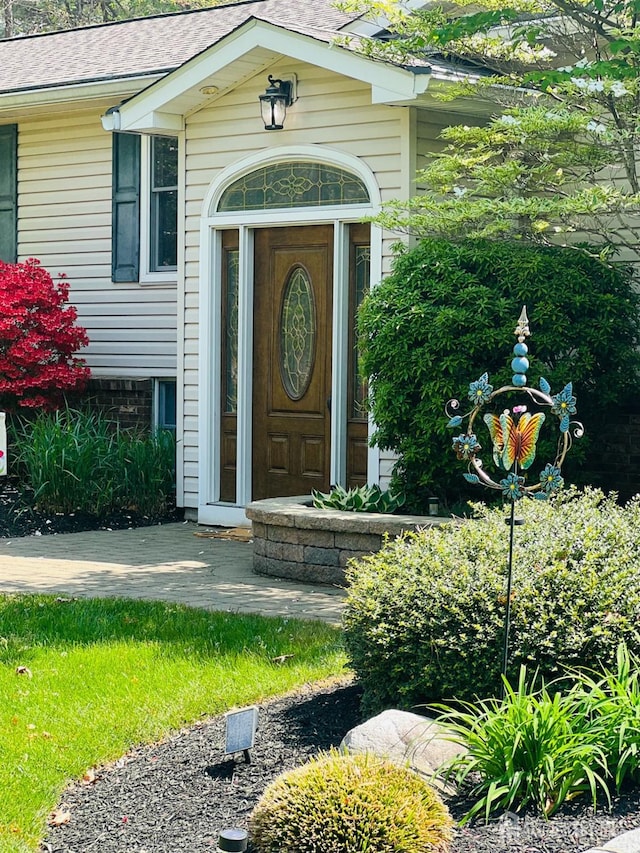property entrance featuring a shingled roof