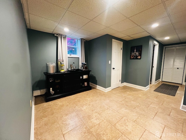 interior space featuring recessed lighting, baseboards, and a drop ceiling