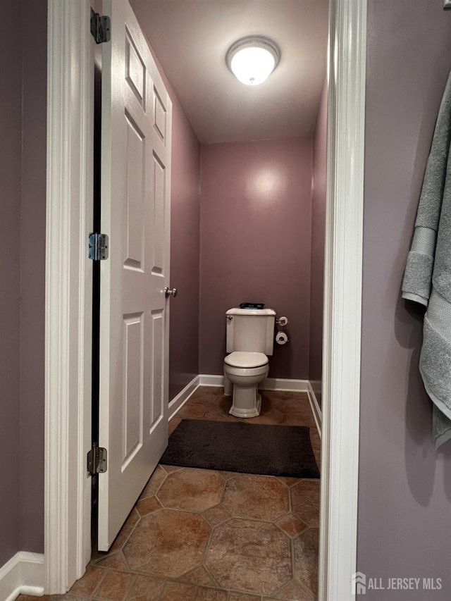 bathroom with toilet and baseboards