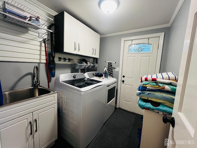 laundry area featuring ornamental molding, a sink, washer and dryer, and cabinet space