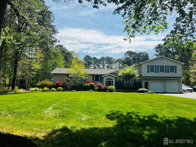 tri-level home with a front lawn, driveway, and a garage
