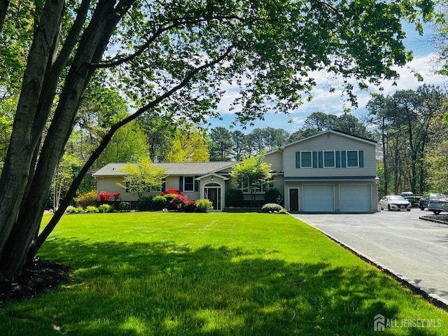 view of front facade featuring a front lawn, a garage, and aphalt driveway