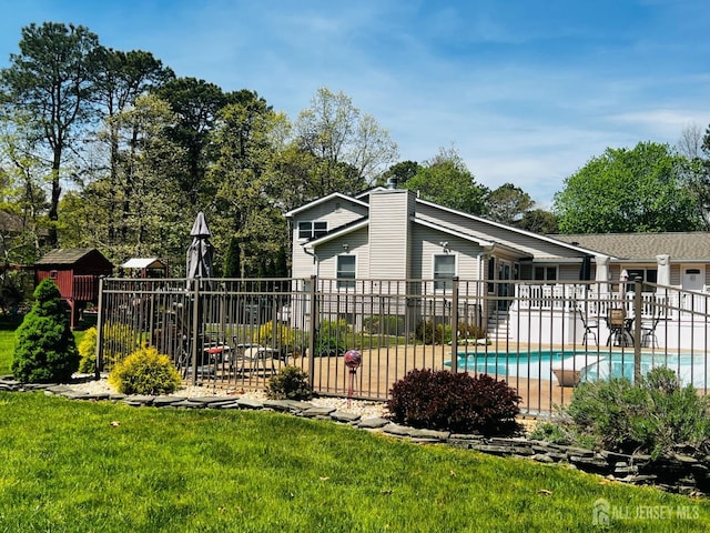 view of pool featuring fence, a lawn, and a fenced in pool