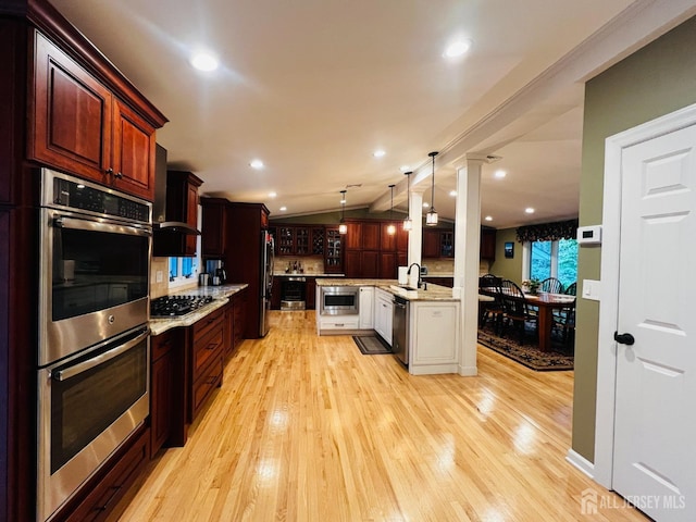 kitchen featuring a sink, vaulted ceiling, light wood-type flooring, and appliances with stainless steel finishes