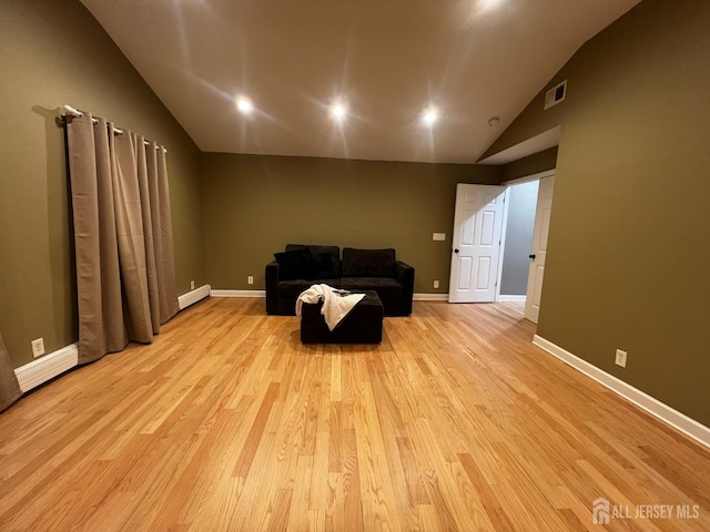 living area featuring light wood-style flooring, visible vents, baseboards, a baseboard heating unit, and vaulted ceiling