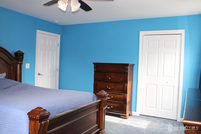 bedroom with ceiling fan, a closet, and light carpet