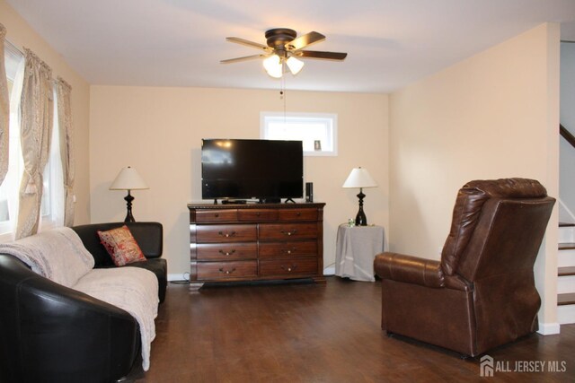 living room featuring ceiling fan and dark hardwood / wood-style flooring