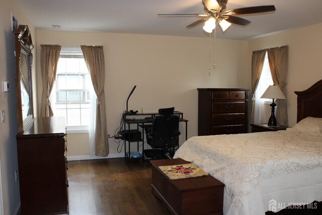 bedroom with ceiling fan, dark hardwood / wood-style floors, and multiple windows