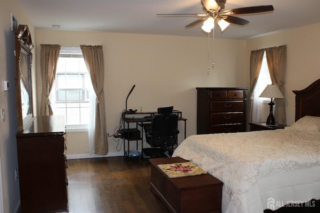 bedroom with multiple windows, dark hardwood / wood-style flooring, and ceiling fan