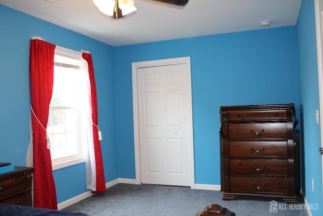 carpeted bedroom featuring ceiling fan and a closet