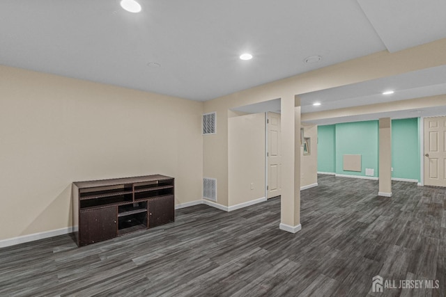 finished basement featuring visible vents, recessed lighting, dark wood-type flooring, and baseboards