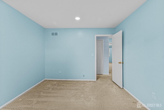 carpeted spare room featuring recessed lighting, baseboards, and visible vents