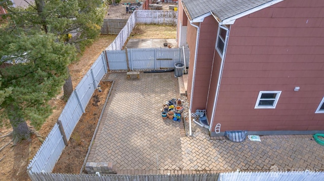 view of side of property with central AC, a fenced backyard, and a patio area