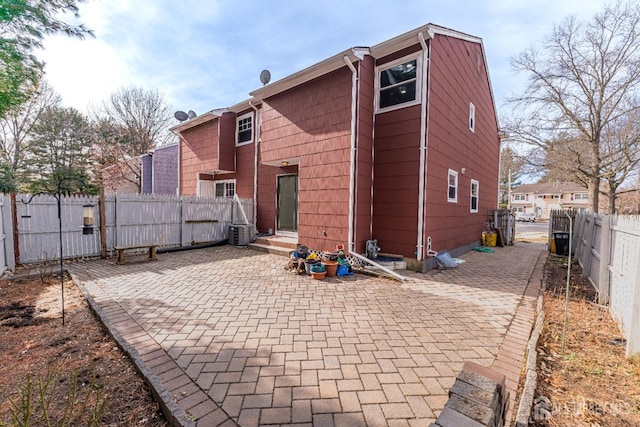 back of property featuring entry steps, a patio area, central AC unit, and a fenced backyard