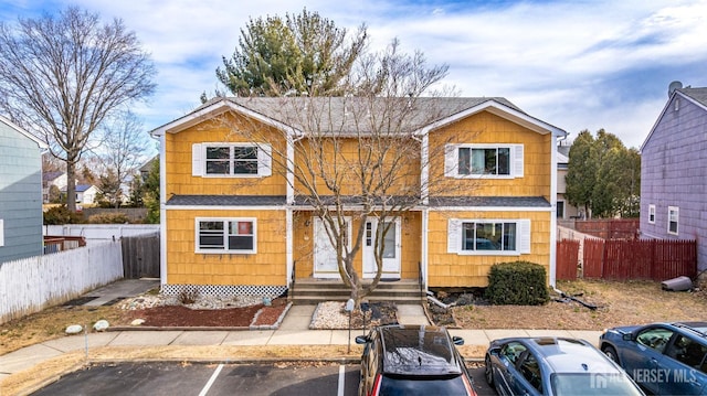 view of front of home with fence and uncovered parking