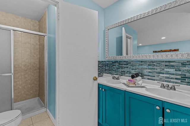 bathroom with tile patterned floors, double vanity, a shower stall, and a sink