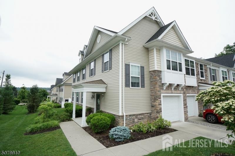 1 Burdett Ln, Verona, NJ 07044 - view of property exterior with stone siding, driveway, a garage, and a lawn