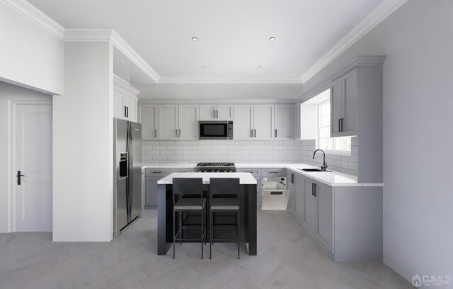 kitchen featuring sink, a center island, appliances with stainless steel finishes, and tasteful backsplash