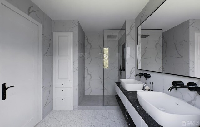 bathroom featuring tiled shower, tile walls, and double vanity