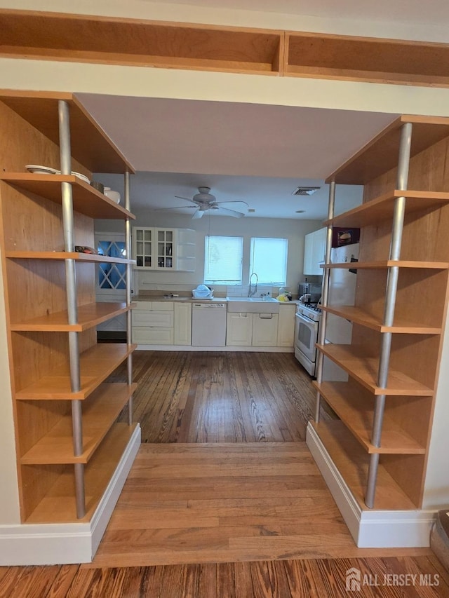 interior space with open shelves, white cabinetry, a sink, white appliances, and dark wood-style flooring