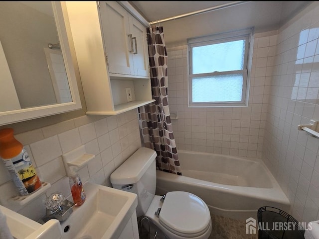 bathroom with tile walls, shower / bath combo, a sink, and toilet