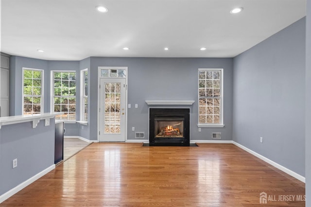 unfurnished living room with light wood-type flooring, visible vents, and recessed lighting