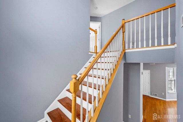 stairs featuring visible vents, baseboards, and wood finished floors