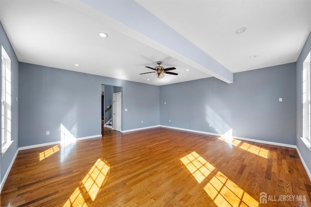 unfurnished room with recessed lighting, wood finished floors, beamed ceiling, baseboards, and stairs