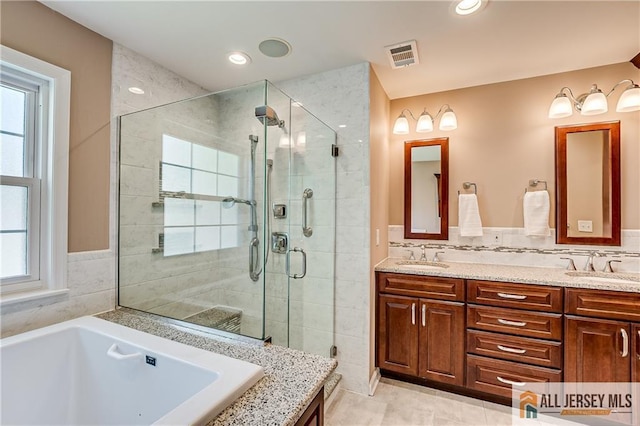 full bathroom featuring plenty of natural light, a sink, a bath, and a shower stall