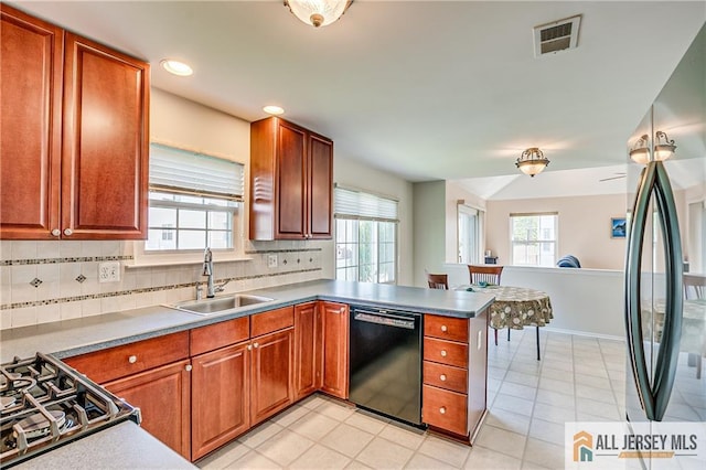 kitchen with stainless steel fridge, a sink, black dishwasher, a peninsula, and tasteful backsplash