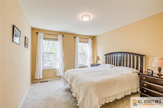 carpeted bedroom featuring baseboards and visible vents