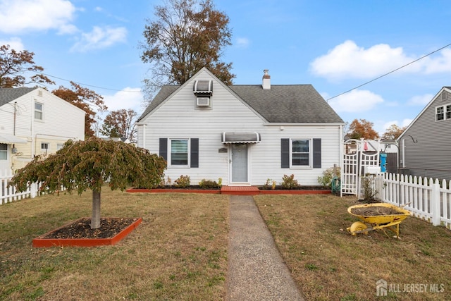 view of front of house with a chimney, a shingled roof, a front yard, and fence