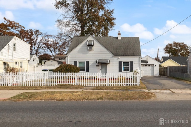 view of front of home featuring a shingled roof, a detached garage, a fenced front yard, aphalt driveway, and a chimney