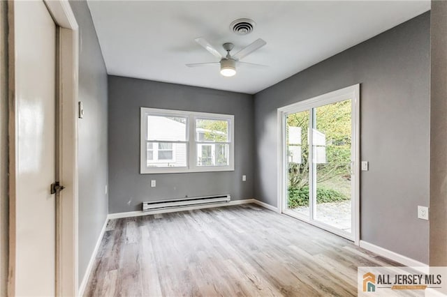 unfurnished room with visible vents, ceiling fan, baseboards, wood finished floors, and a baseboard radiator