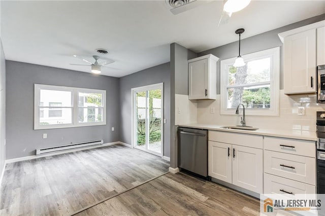 kitchen featuring a sink, stainless steel dishwasher, light wood-style floors, a baseboard radiator, and ceiling fan