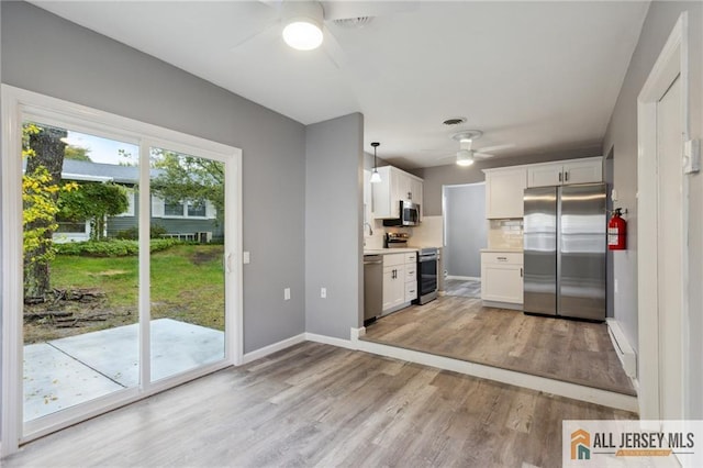 kitchen featuring white cabinetry, light wood-style floors, appliances with stainless steel finishes, light countertops, and ceiling fan